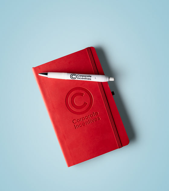 Red notebook with a pen on a light blue background