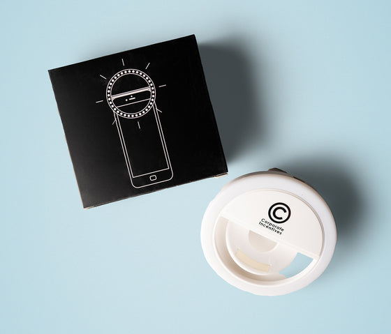 White circular device with a logo on a black box with a phone illustration on a light blue background